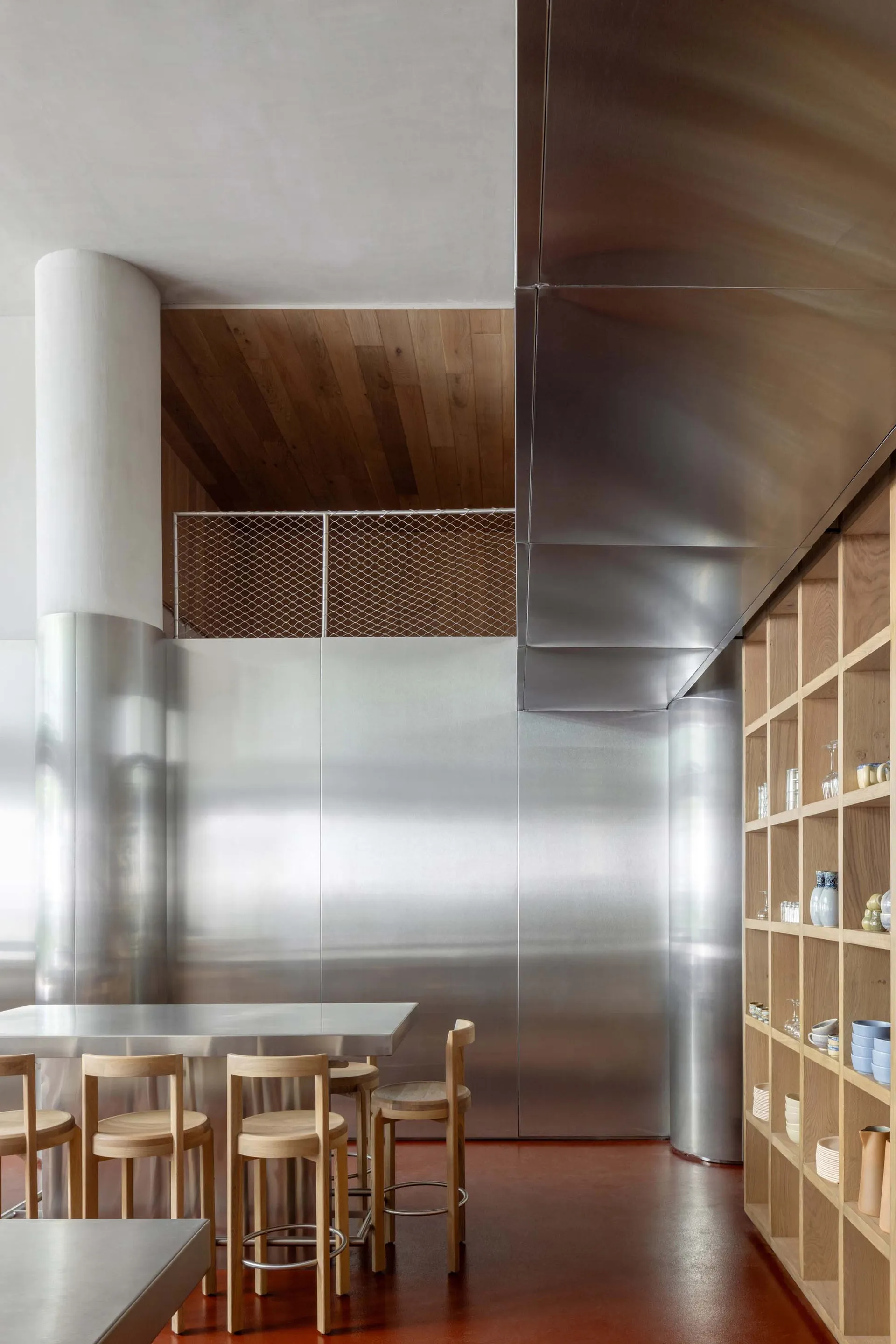 An industrial-looking commercial space featuring metallic walls and wooden furniture.