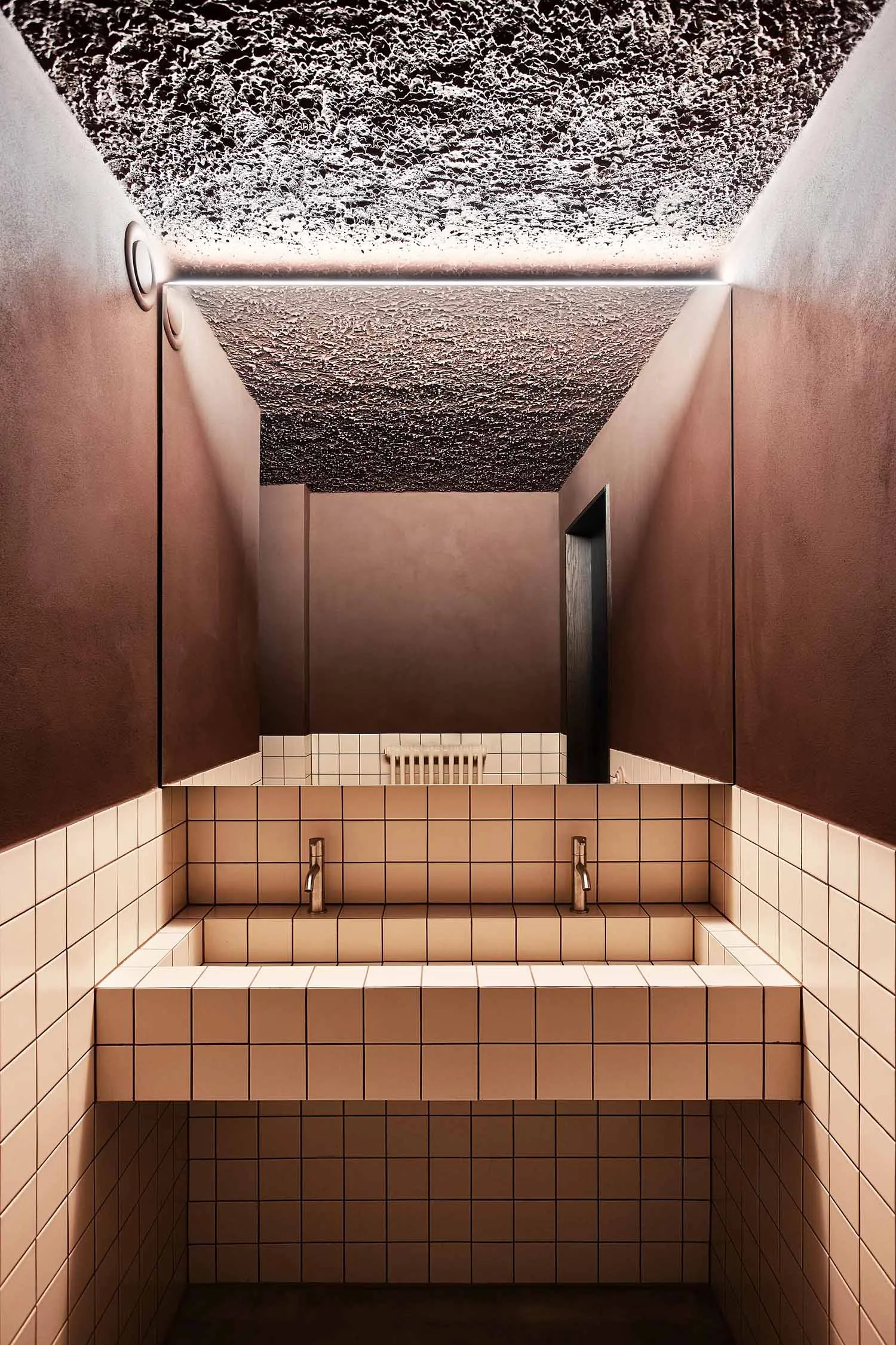 Public toilet with modern design featuring concrete walls and tiled floor