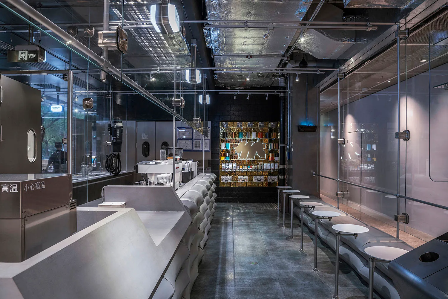 Industrial-style coffee shop with modern glass, concrete, and metallic materials.