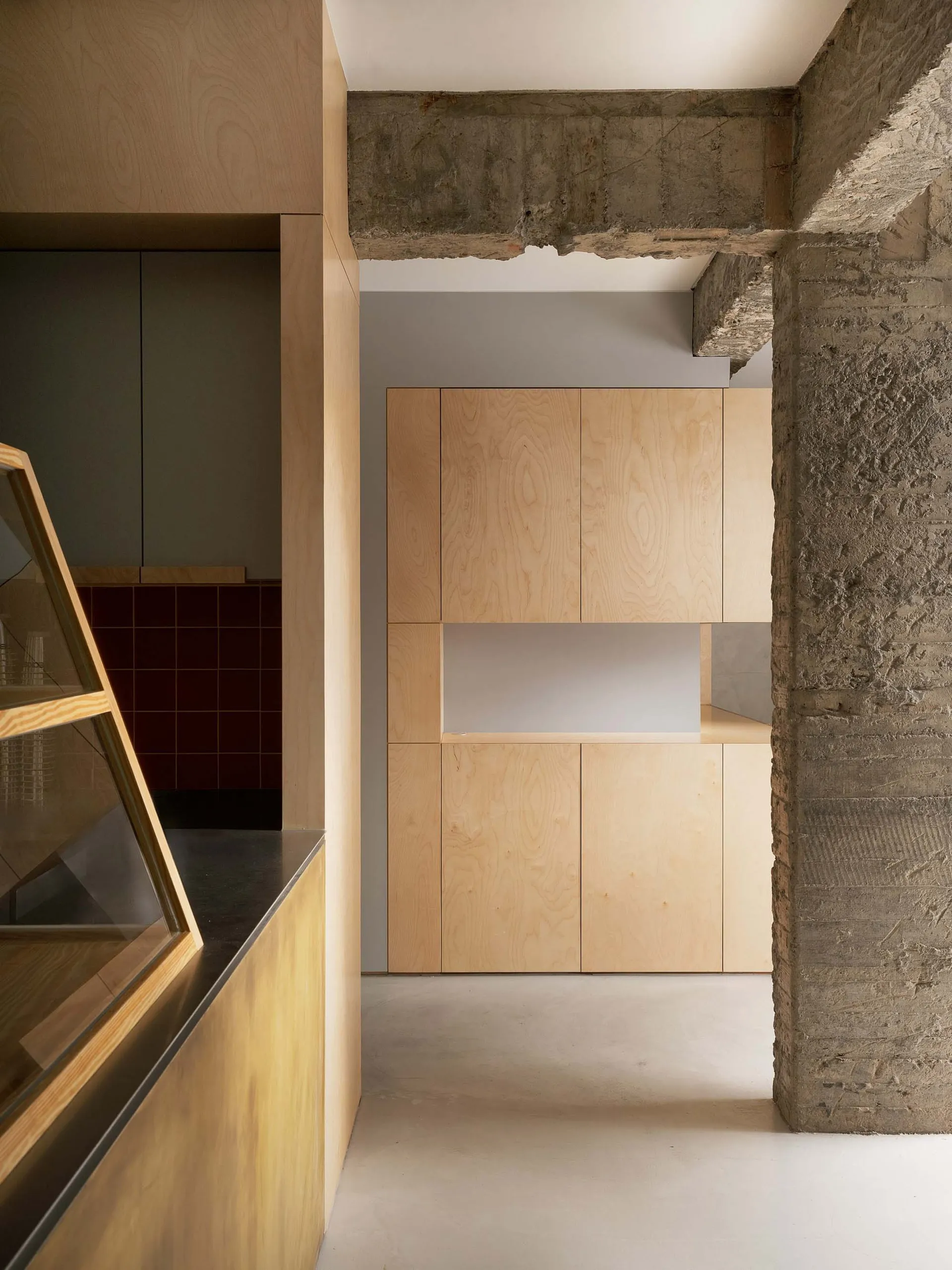 Modern minimalist kitchen with flat-pack wooden cabinets and concrete accents.