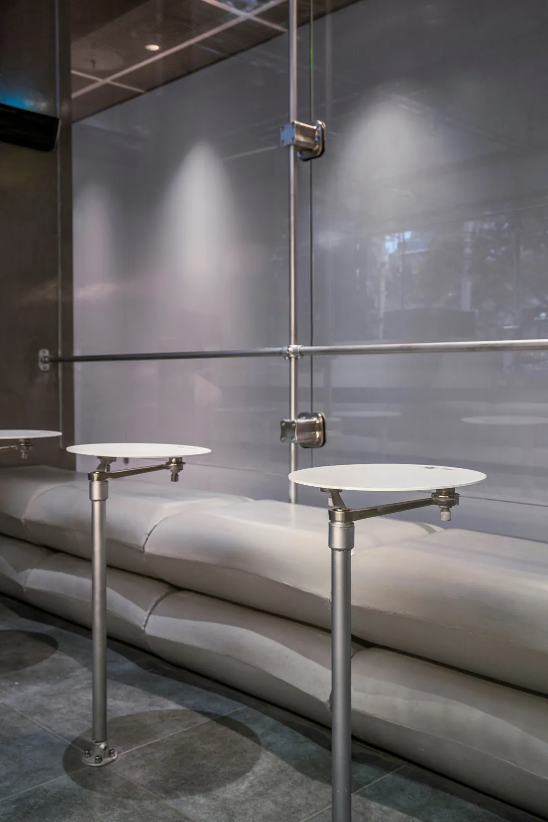 A sleek, modern restaurant bar featuring polished concrete surfaces and minimalist design elements.