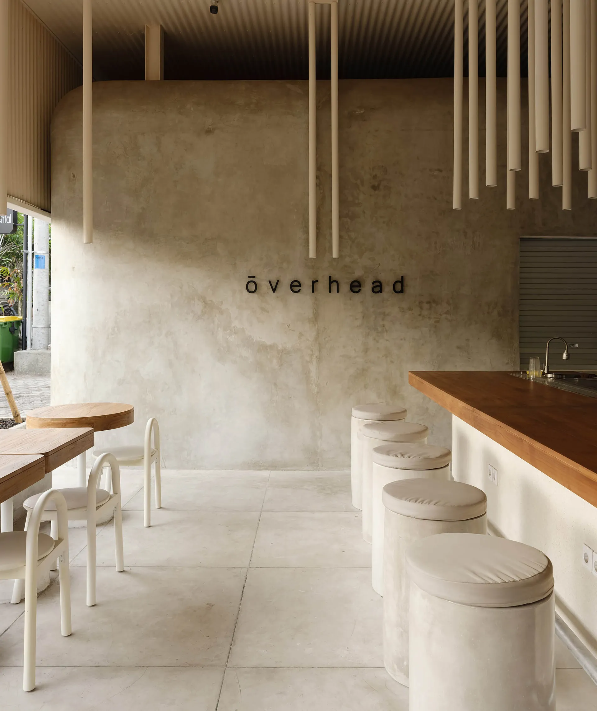 A minimalist cafe interior featuring concrete and wood materials.