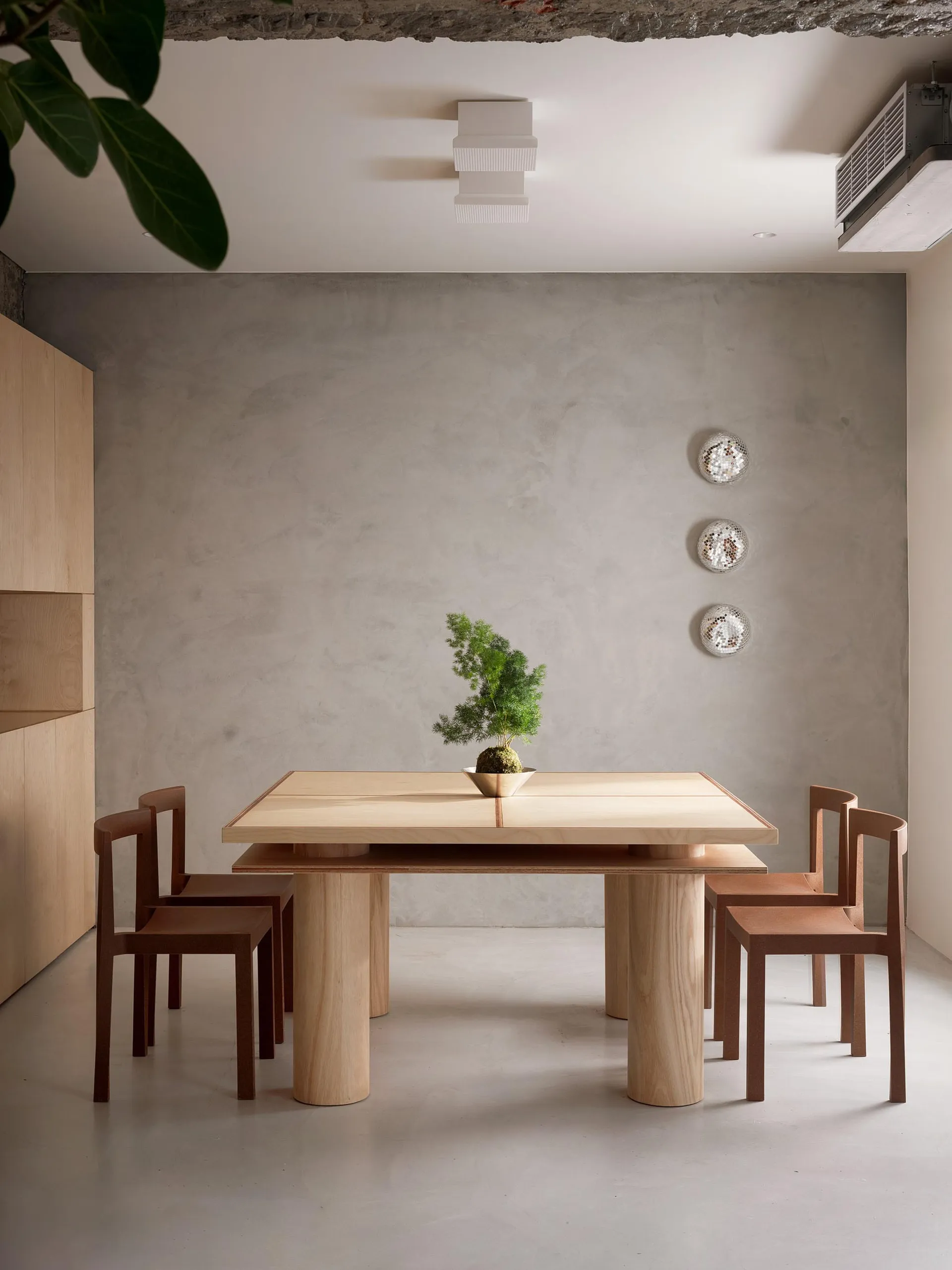 A modern wooden dining table with chairs in a minimalist interior design setting.