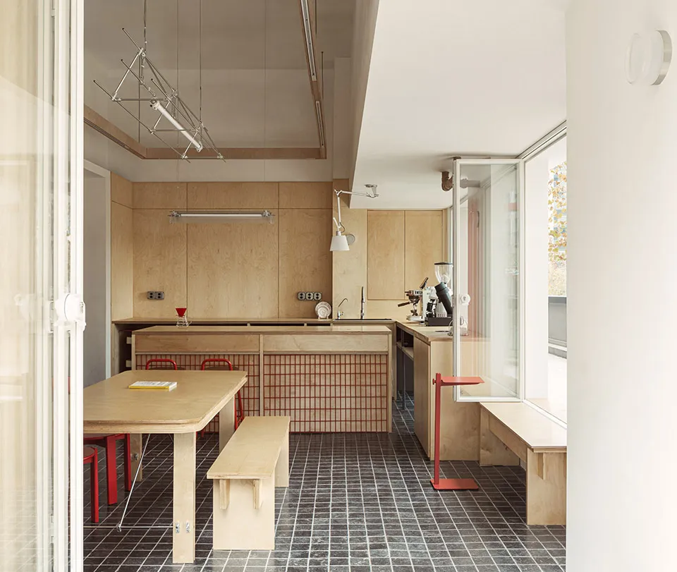 A minimalist kitchen with wooden furniture and a small window.