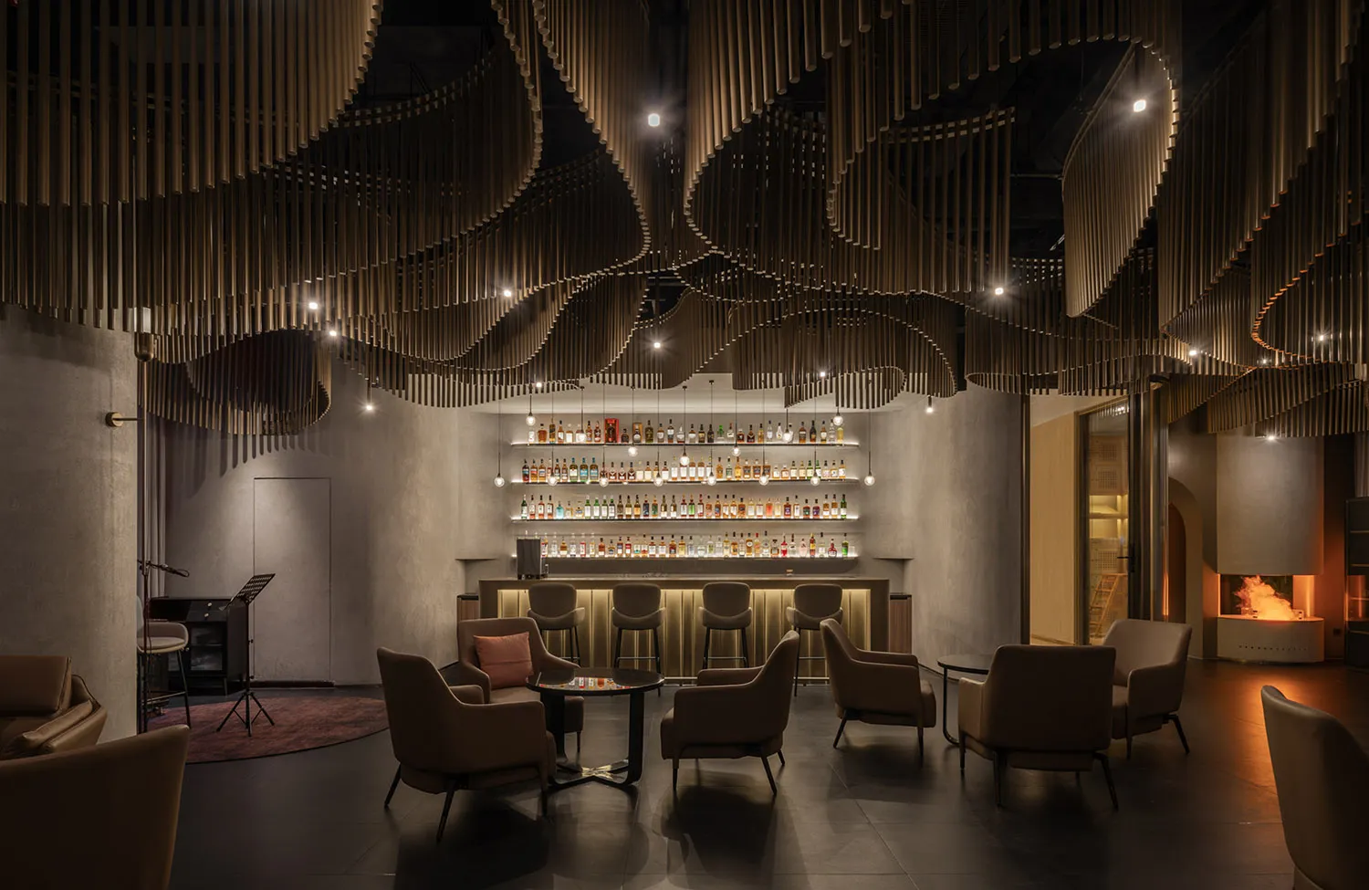 A modern bar and lounge interior with dark accents, featuring a wooden ceiling design and metal railings.