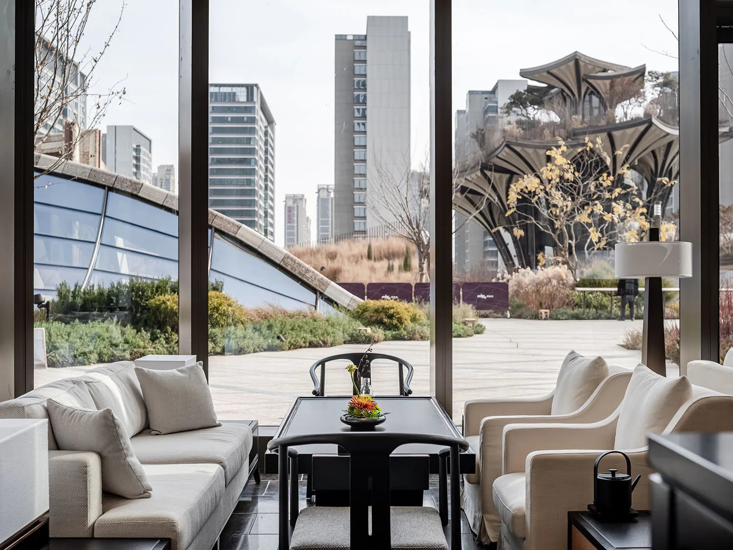 Modern hospitality interior with minimalist design, featuring white seating and a sleek table with a floral centerpiece.