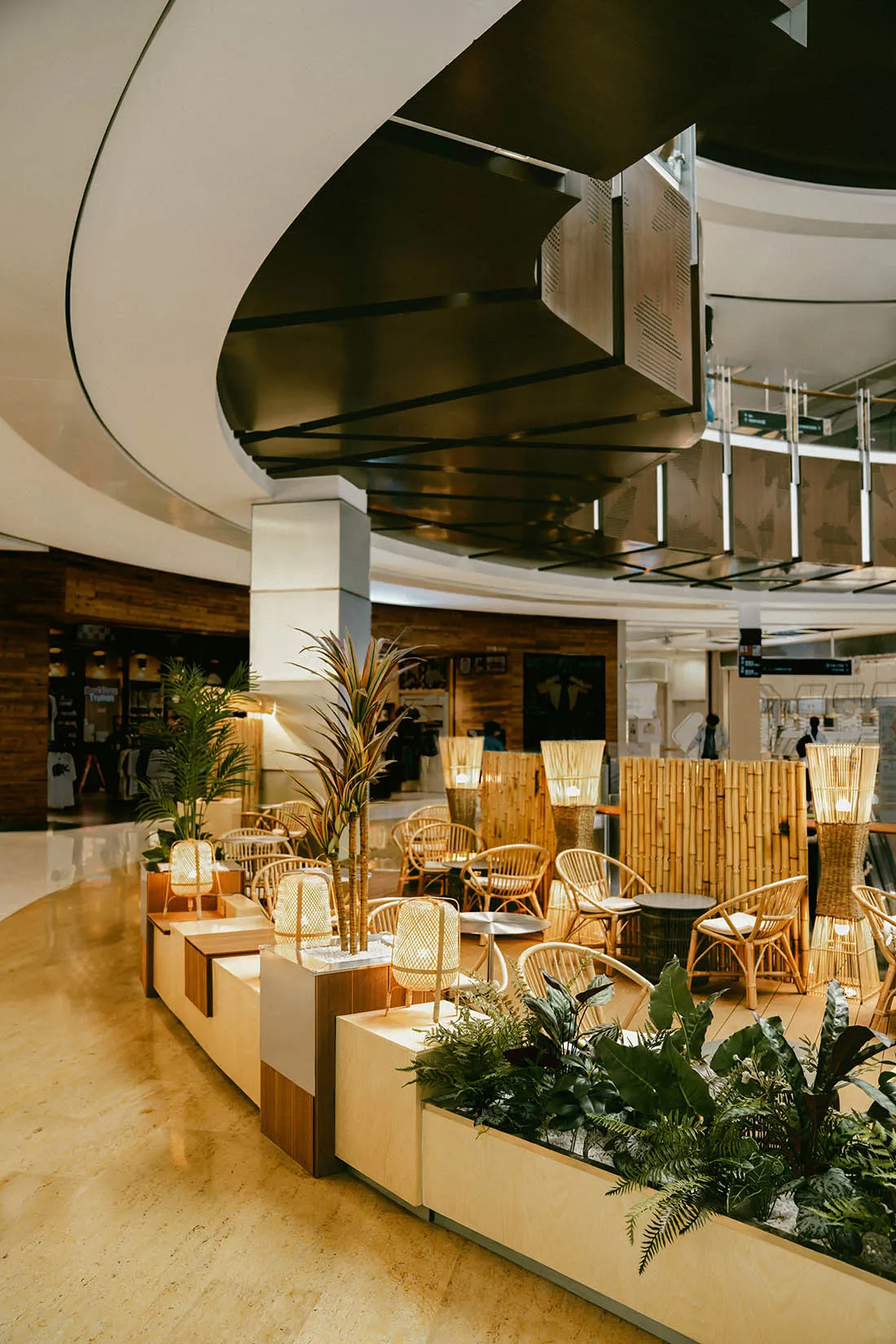 A tropical-themed restaurant interior with bamboo planters and woven furniture