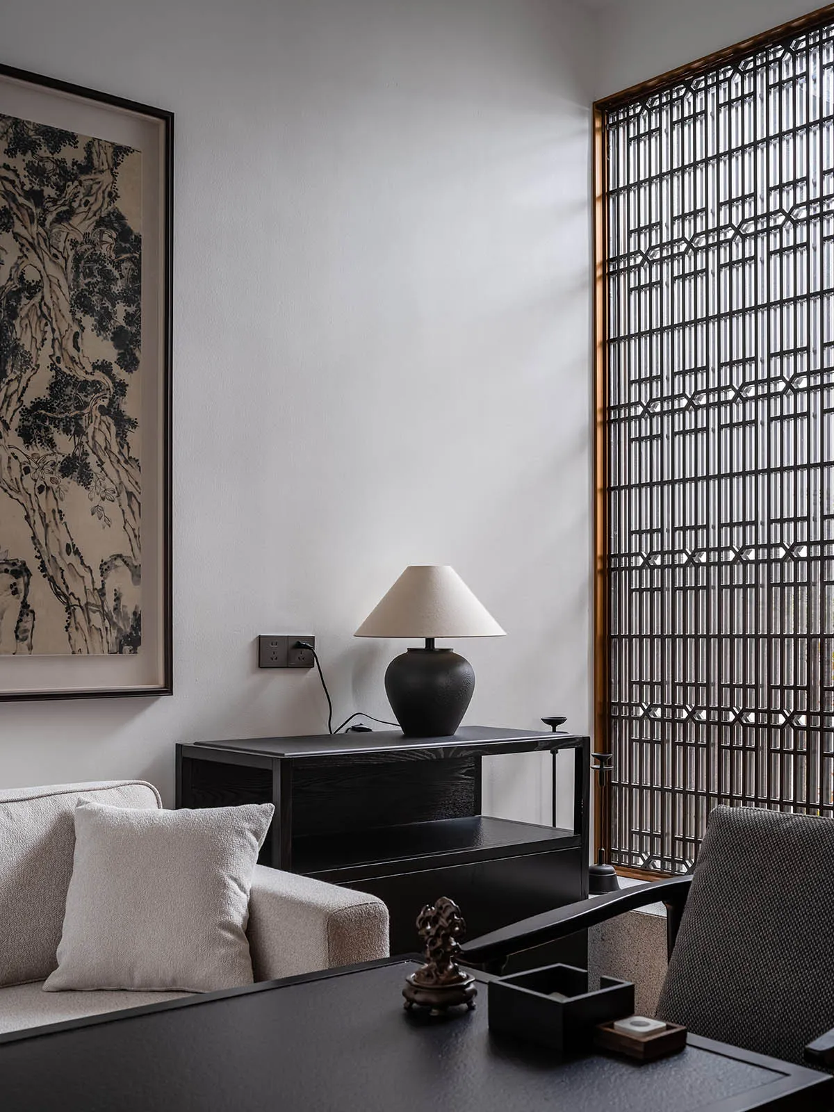 A modern minimalist living room featuring black furniture and neutral tones.