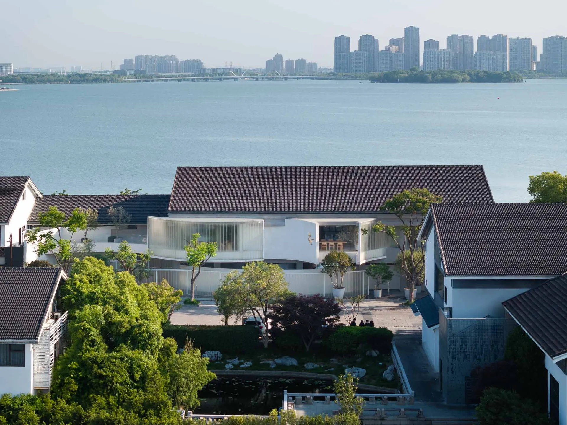 現代住宅採用玻璃、混凝土與木質元素，坐落於水邊