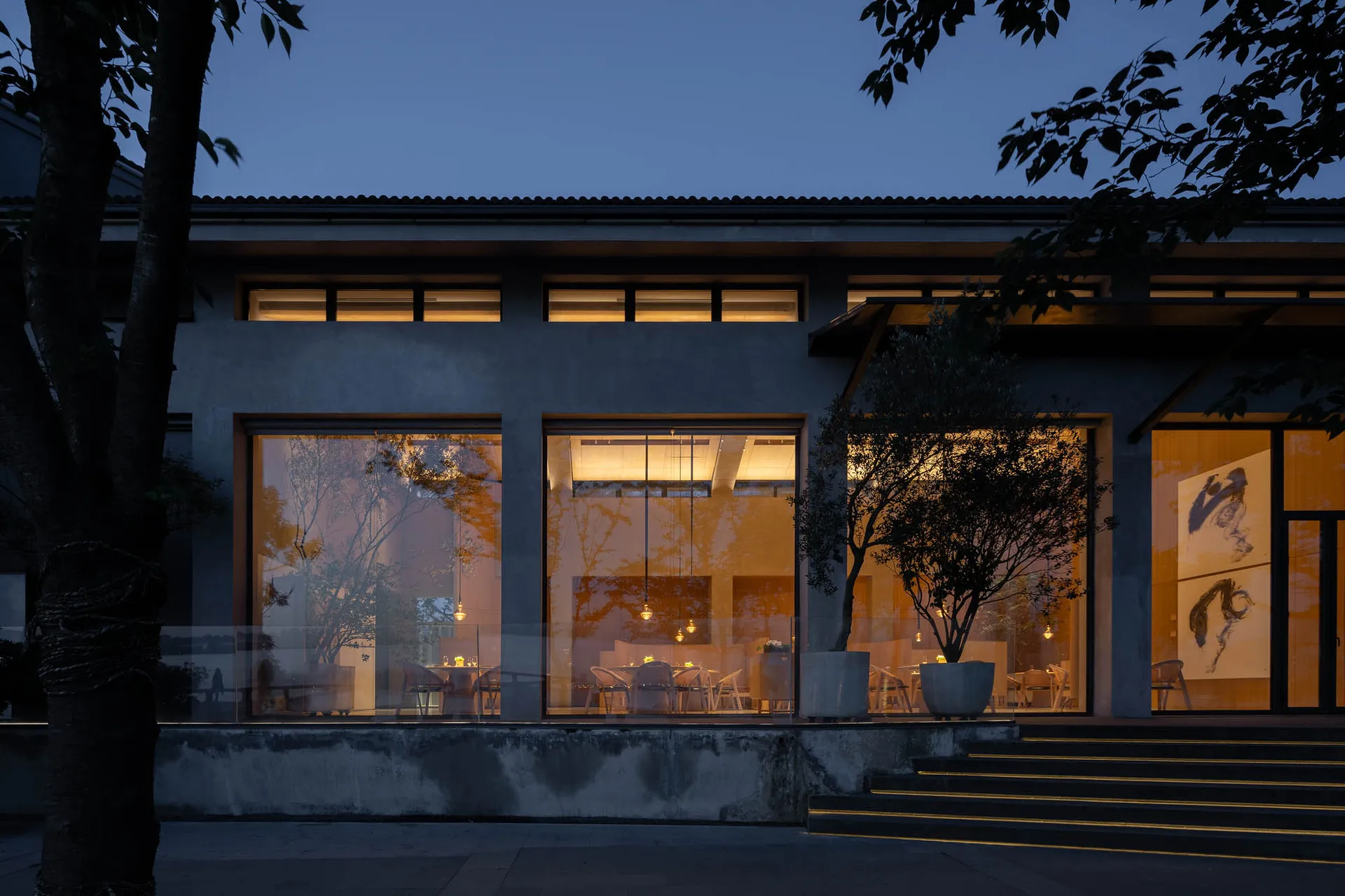 現代餐廳外觀,混凝土框架搭配玻璃窗,夜間景色