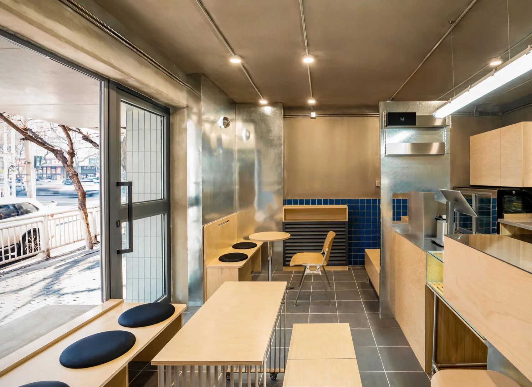 Modern industrial cafe with metallic surfaces and seating areas