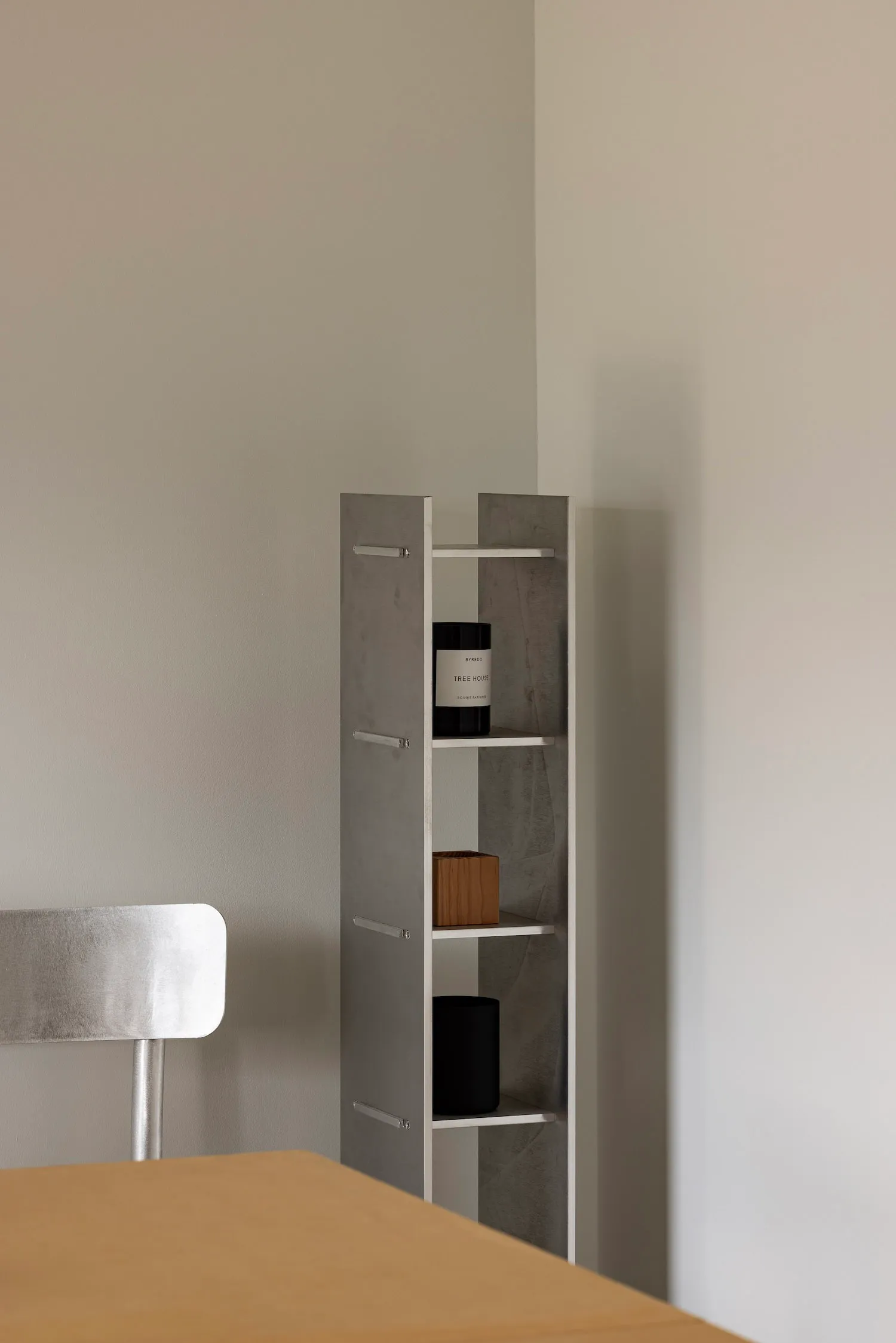 A minimalist concrete shelving unit with a sleek, modern design, featuring geometric angles and a muted, industrial aesthetic
