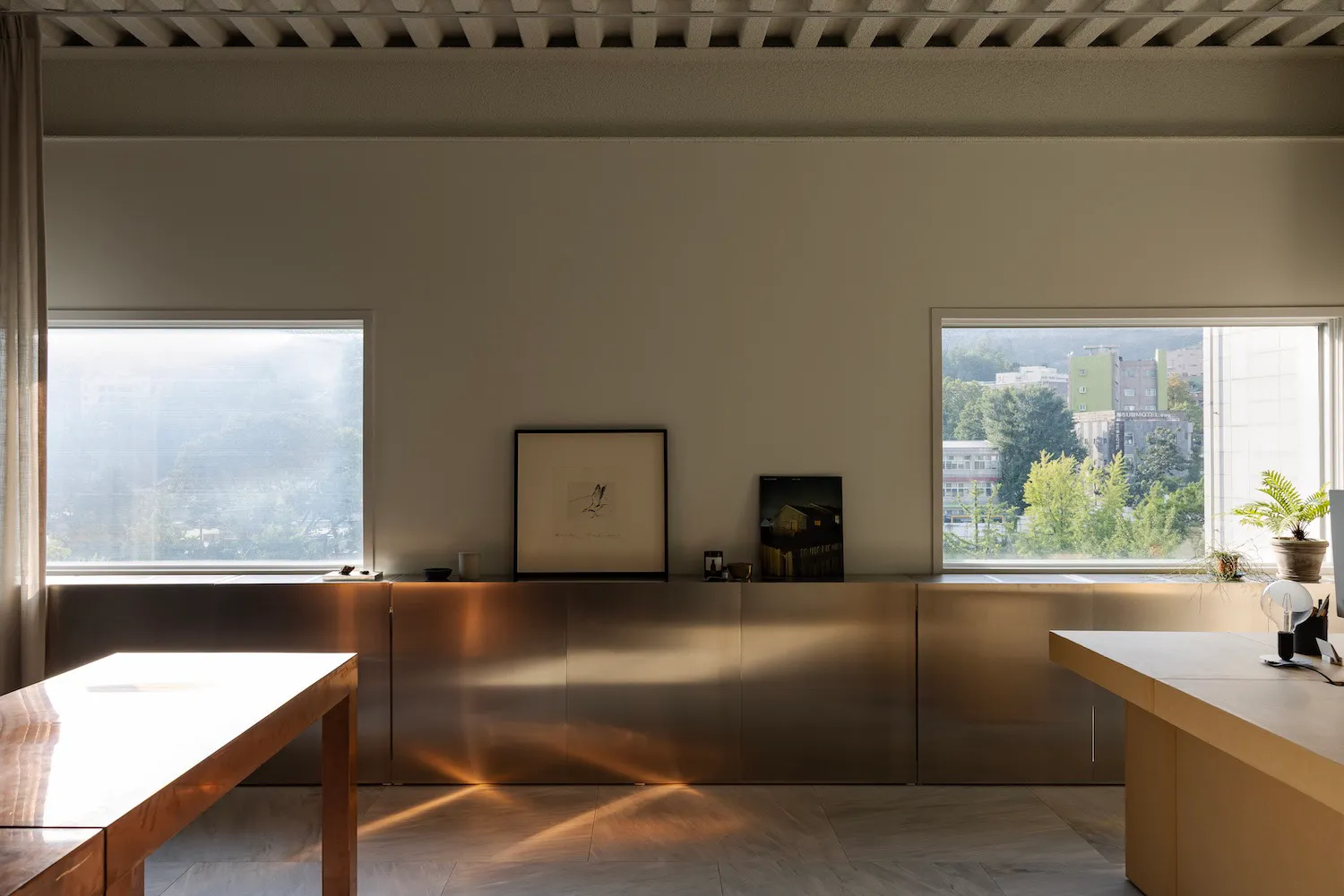 Modern office space featuring metallic cabinets, with views of the cityscape through the windows.