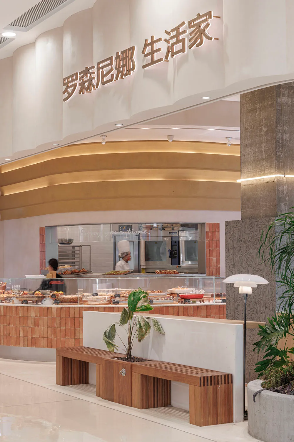 A modern restaurant interior featuring concrete, tile, and glass materials.