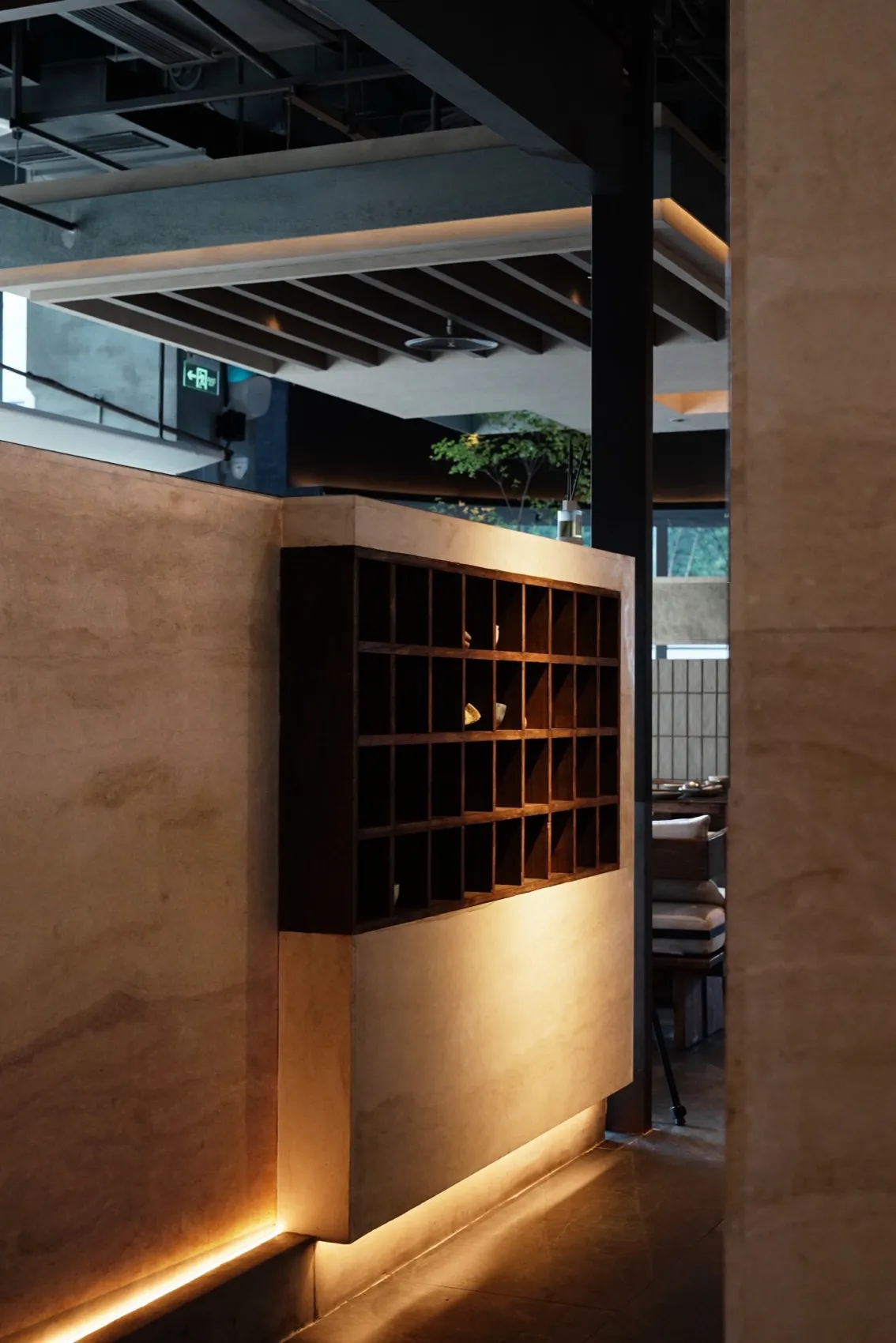 A modern restaurant interior featuring wooden shelves and warm lighting.