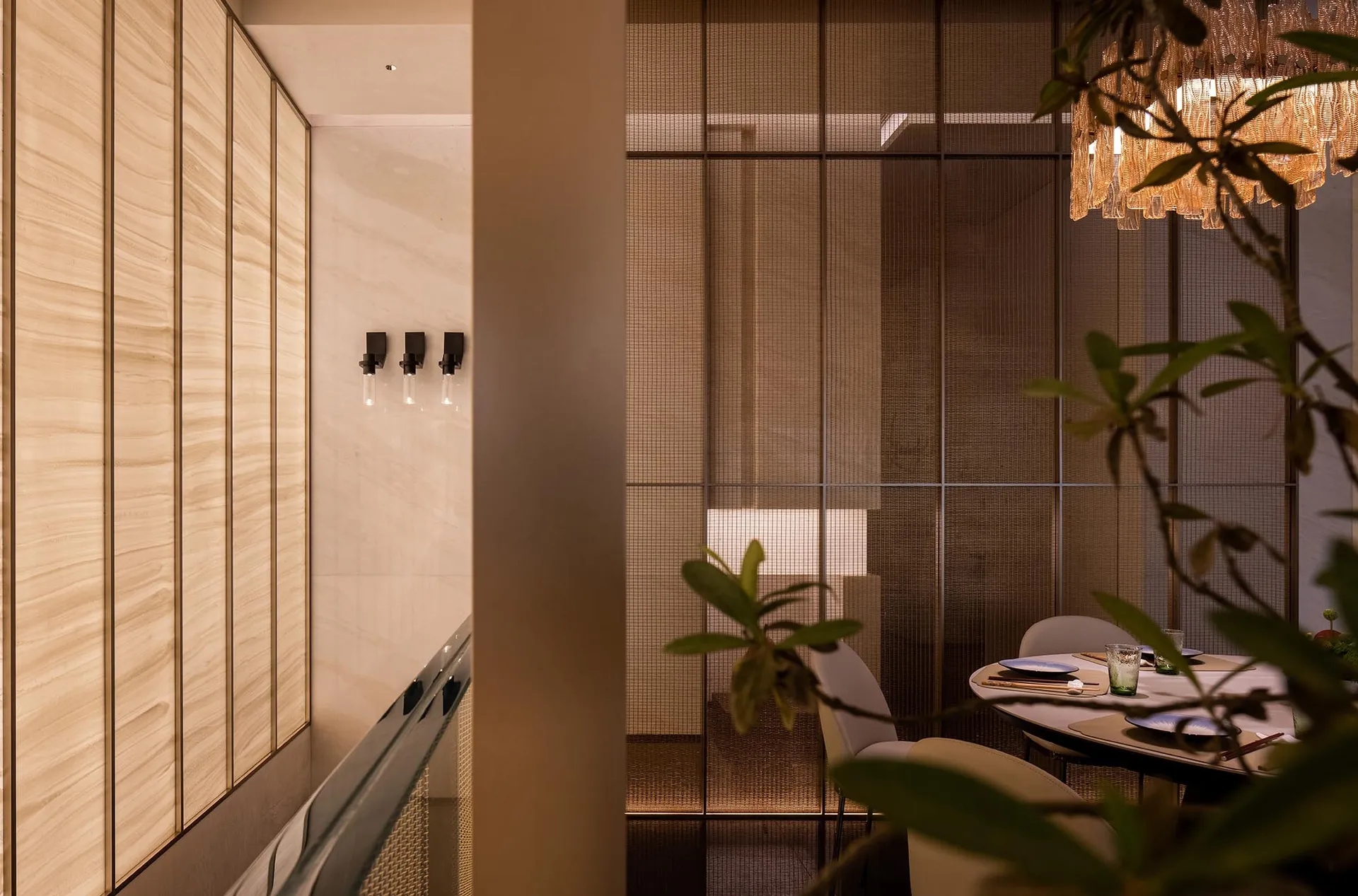 Interior of a minimalist restaurant featuring glass walls and a modern dining setup.