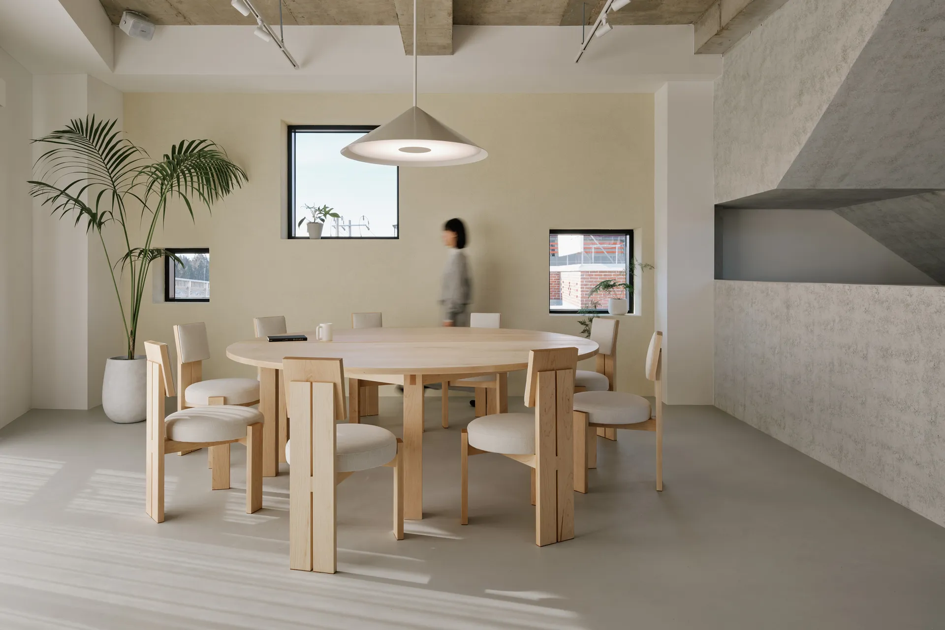 Modern office space with wooden table, concrete floor, and glass elements