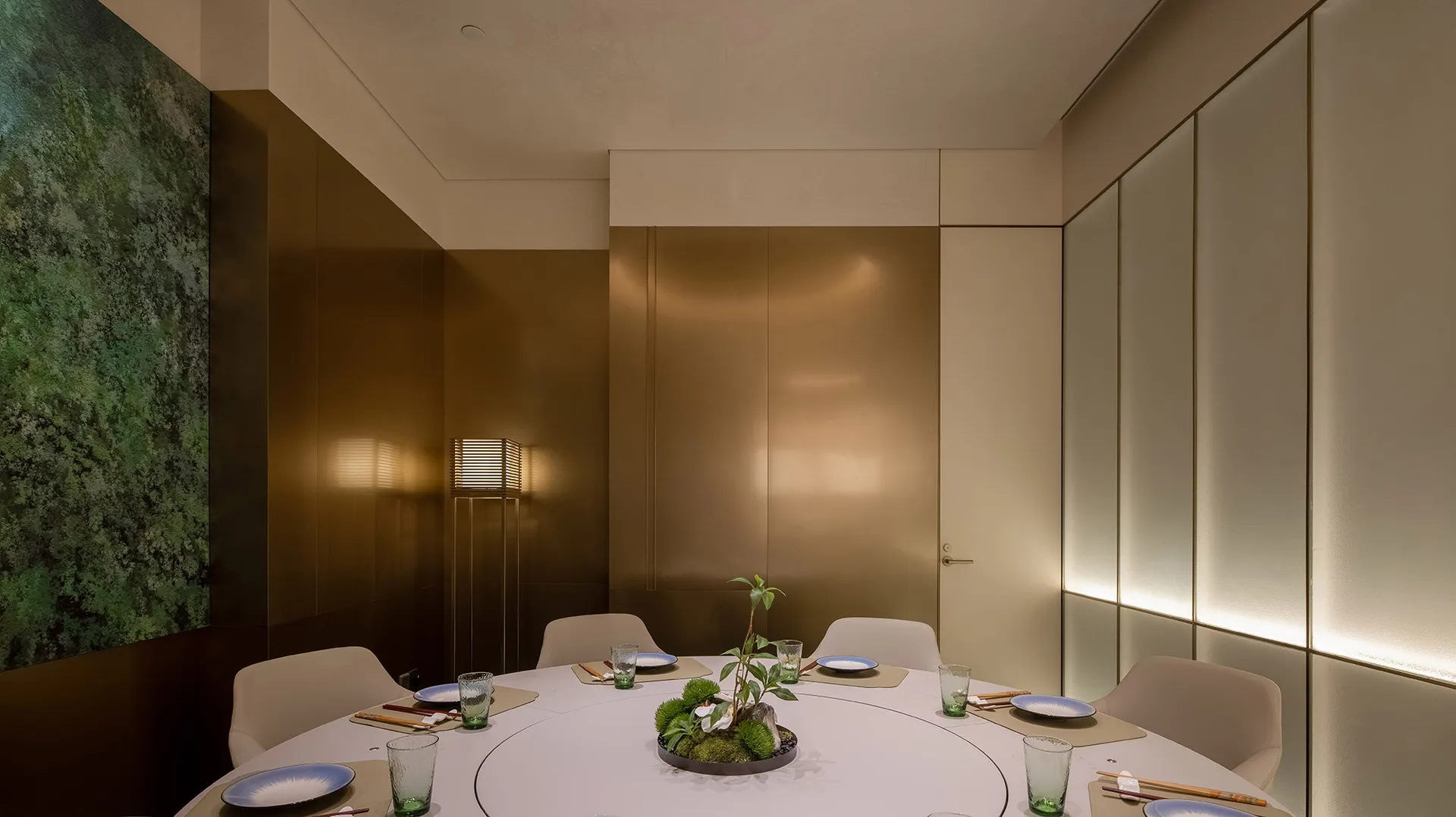 現代金屬風格的餐廳用餐空間,設有可供六人使用的圓形餐桌,搭配簡約桌心裝飾與氛圍燈光