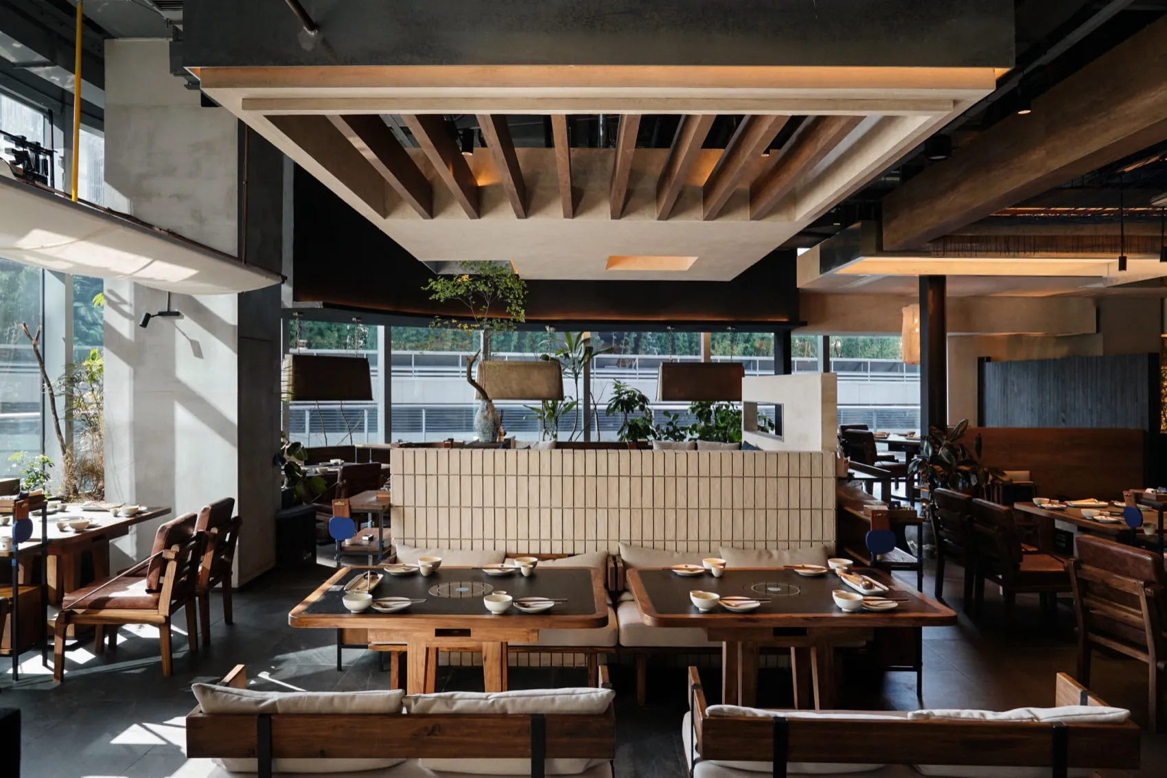 Contemporary restaurant interior featuring wooden tables and concrete walls.