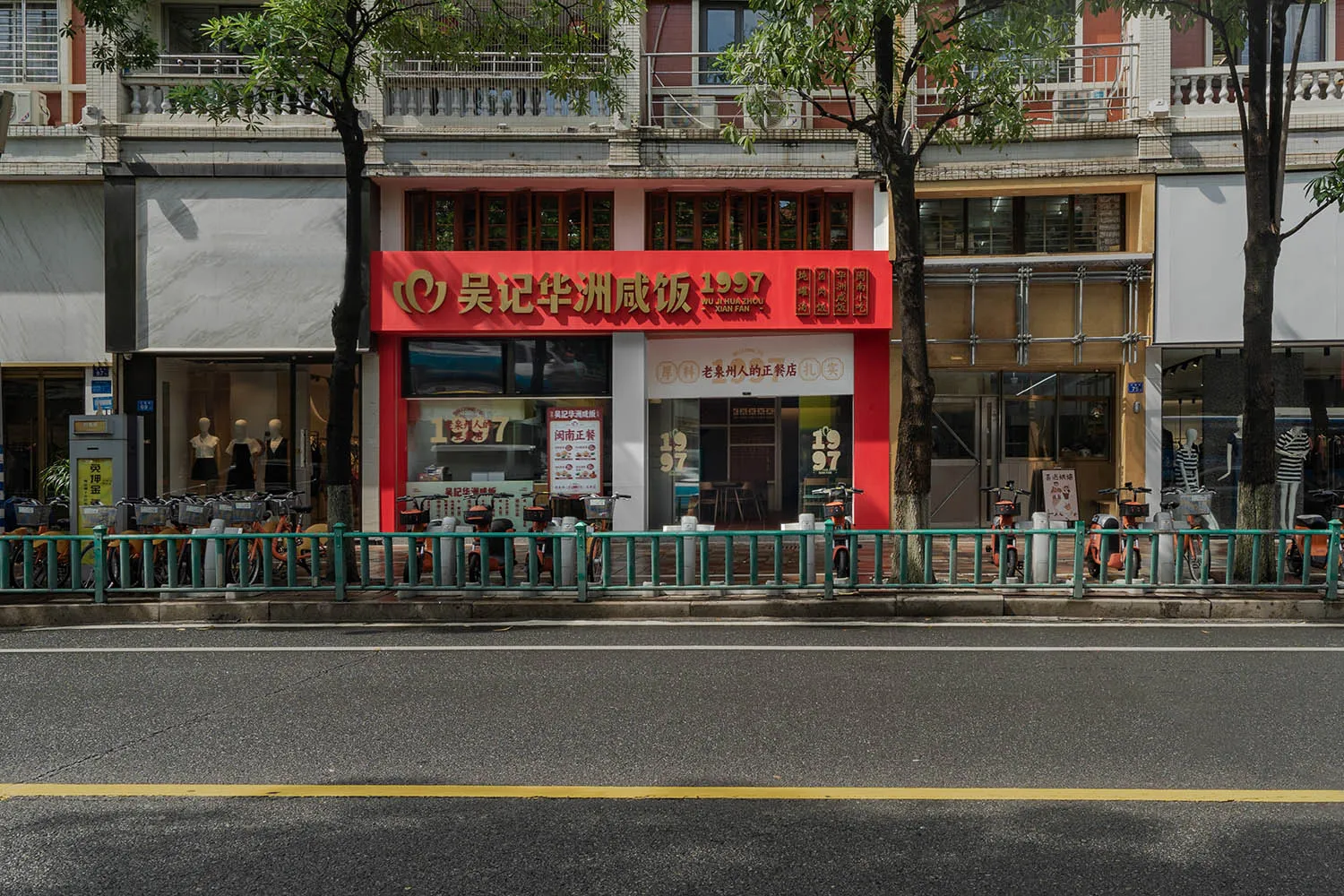 A city street scene featuring a storefront with a red awning and glass windows.