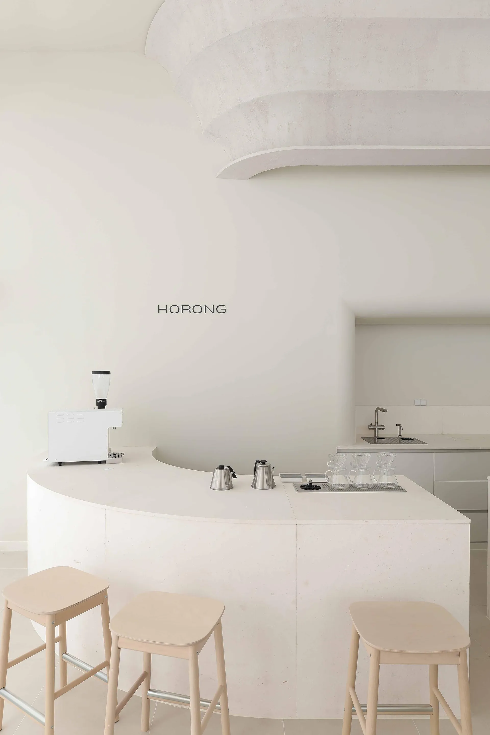A minimalist coffee bar featuring concrete materials and a sleek design.