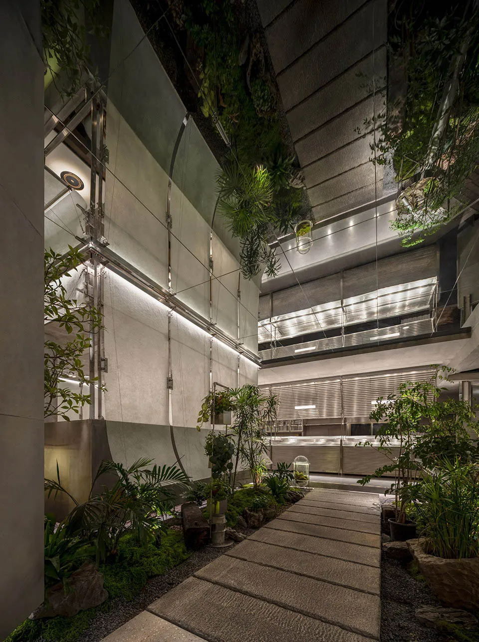 A minimalist commercial interior with concrete walls and lush greenery.