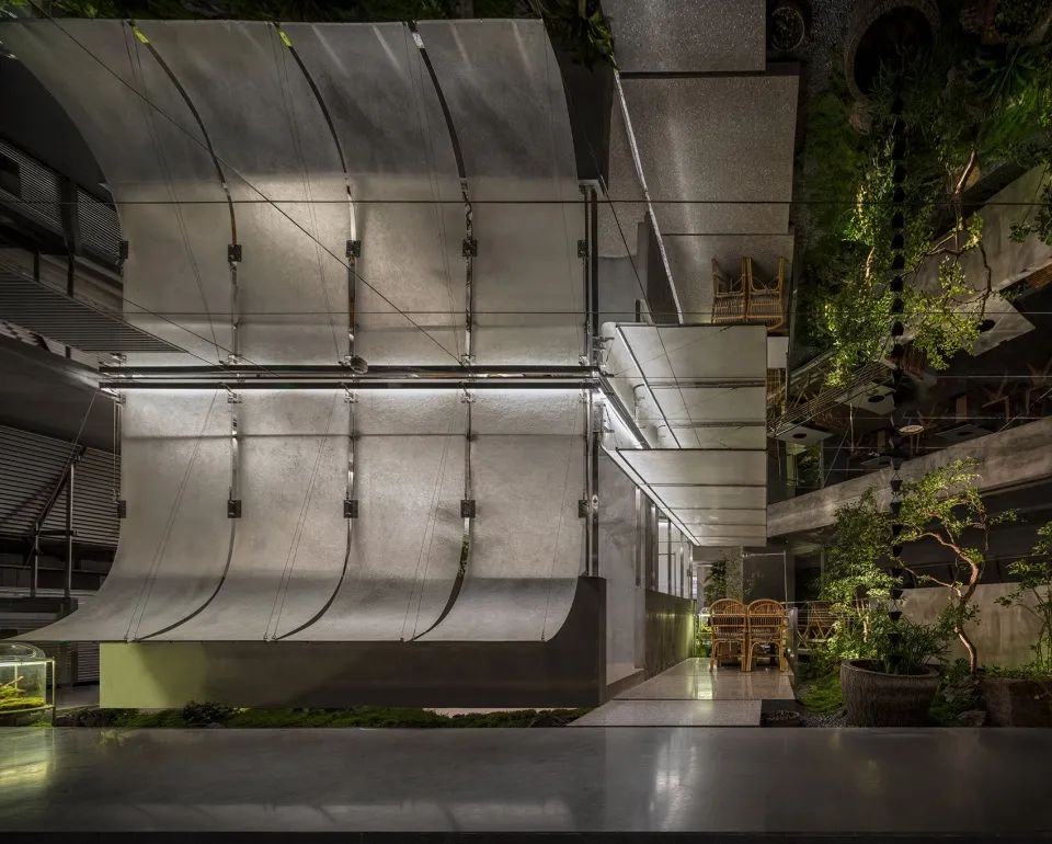 A sleek, modern restaurant interior featuring metallic and concrete materials.