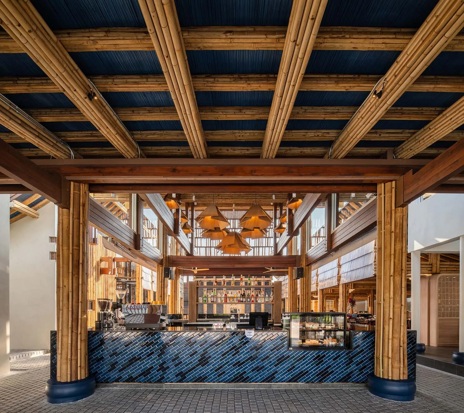 Modern coffee shop interior featuring a wooden bar and blue tiled flooring.
