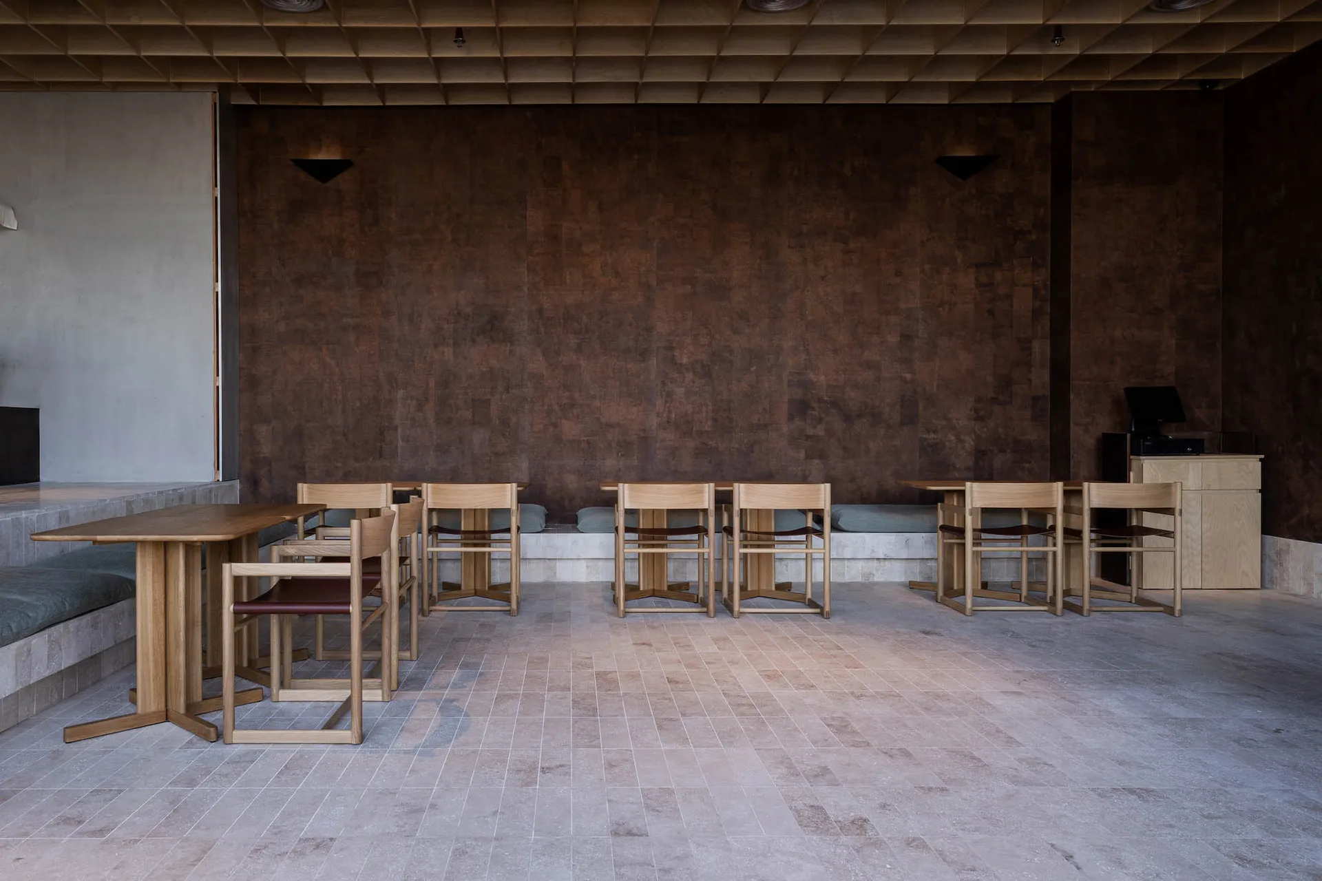 A modern cafe with wooden tables and concrete walls