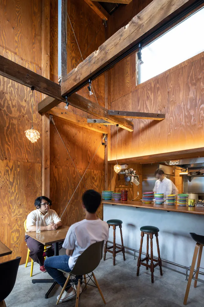 Cafe interior with wood walls, wooden beams, and stools.