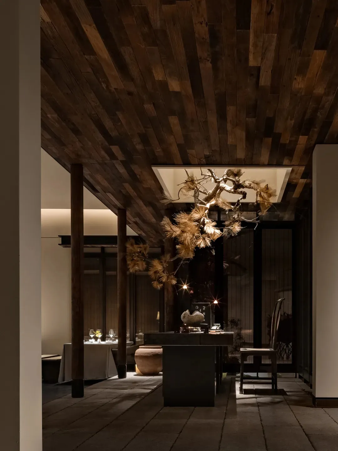 A minimalist restaurant interior with wooden structures and natural lighting.