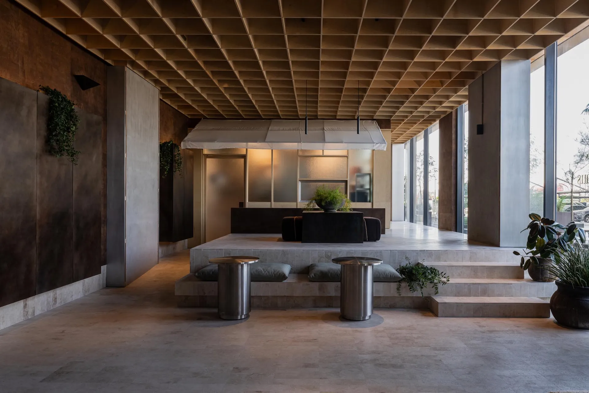 Modern hotel lobby with minimalist design and concrete materials.