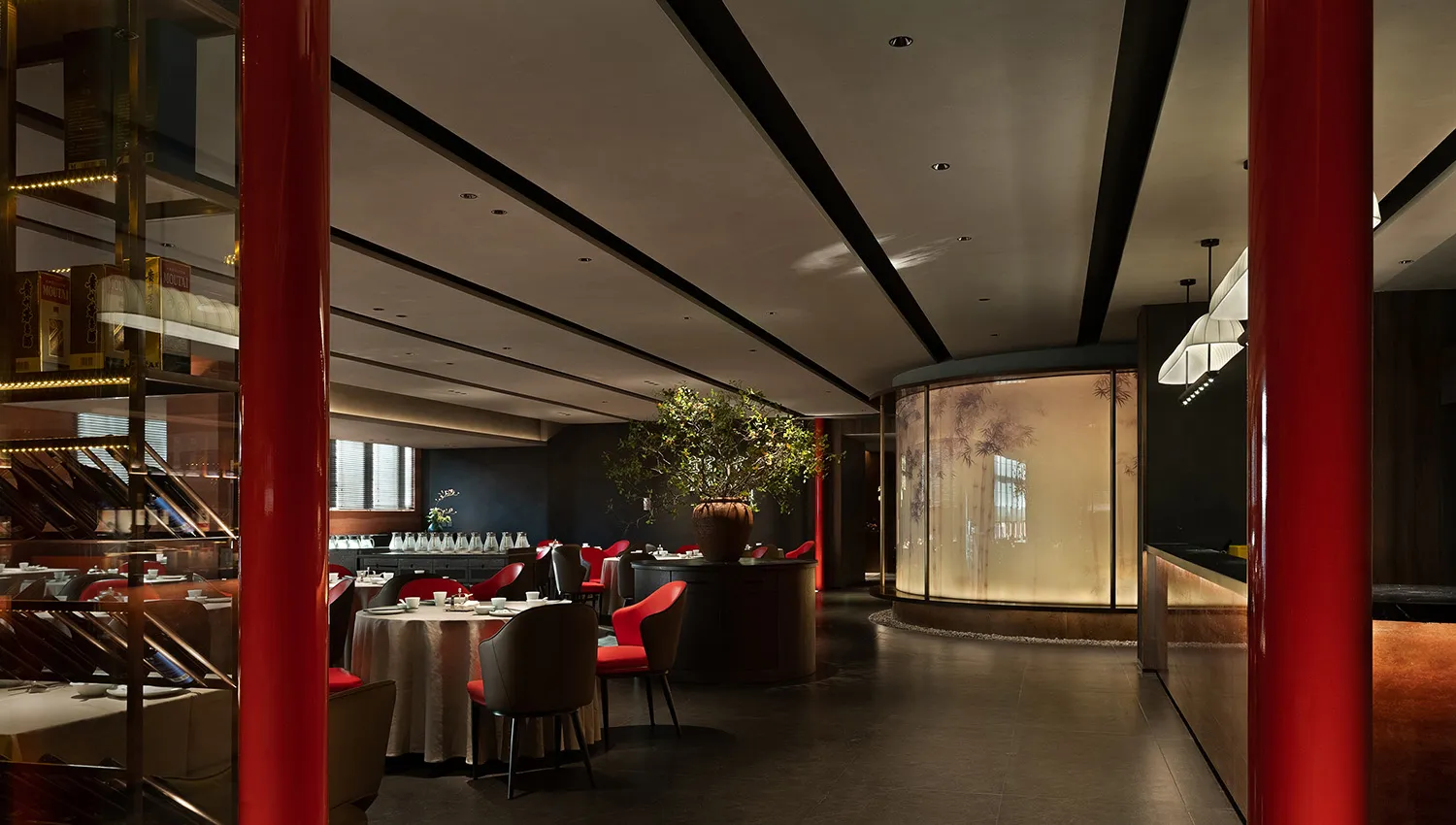奢華的中式料理餐廳,餐桌已擺設妥當,紅黑兩色為主色調,搭配大型盆栽