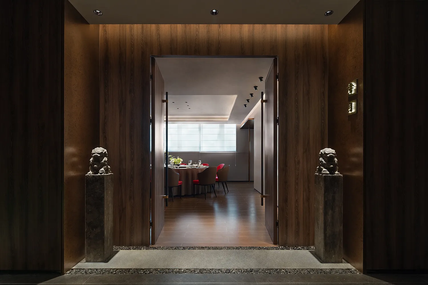 Modern restaurant interior with wooden walls and a dining area.
