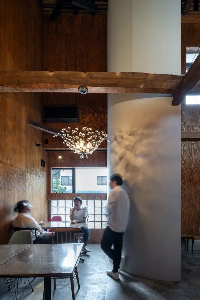 An industrial-style coffee shop interior with wooden walls and a modern chandelier.