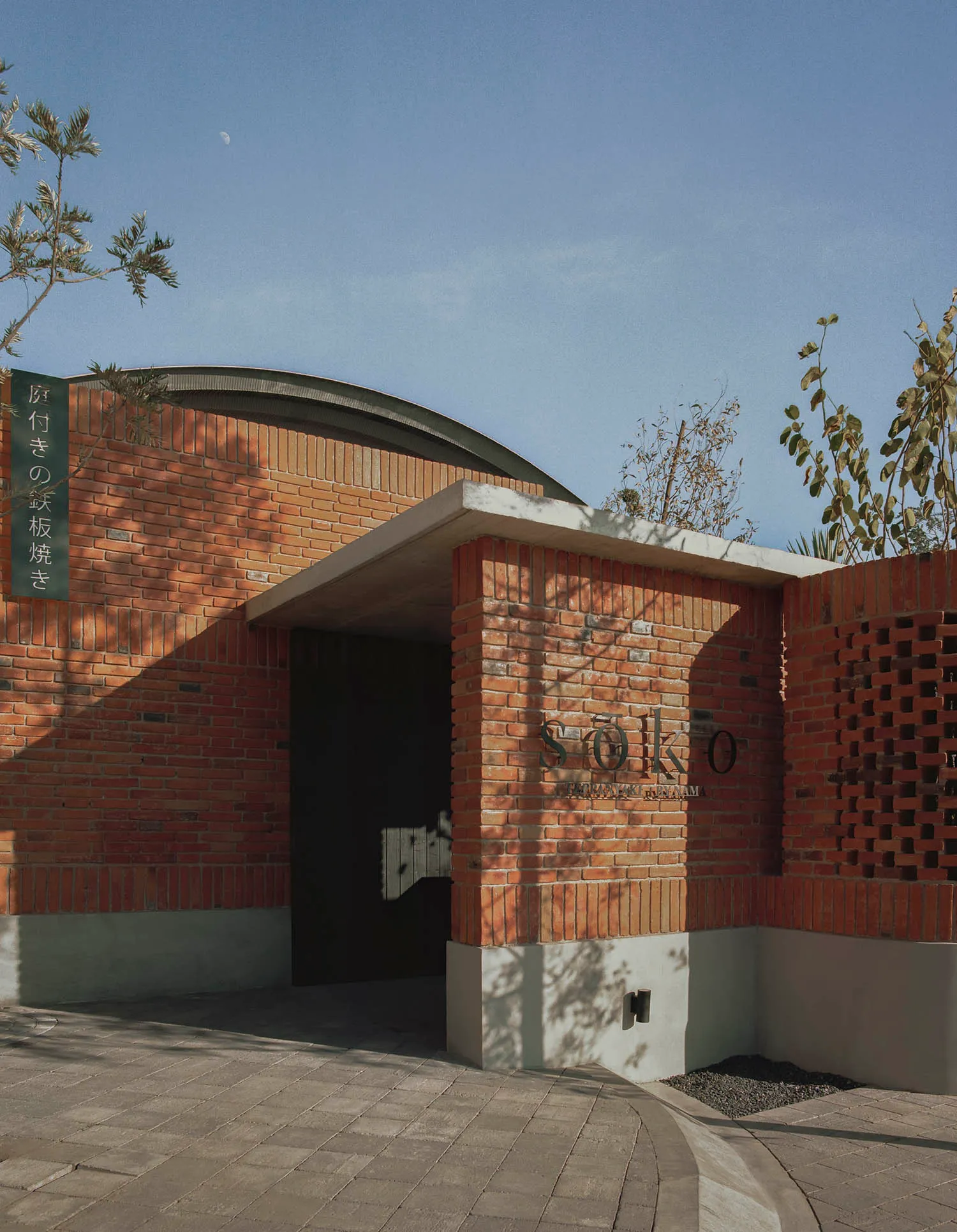 磚造餐廳入口,設有遮陽篷與招牌。