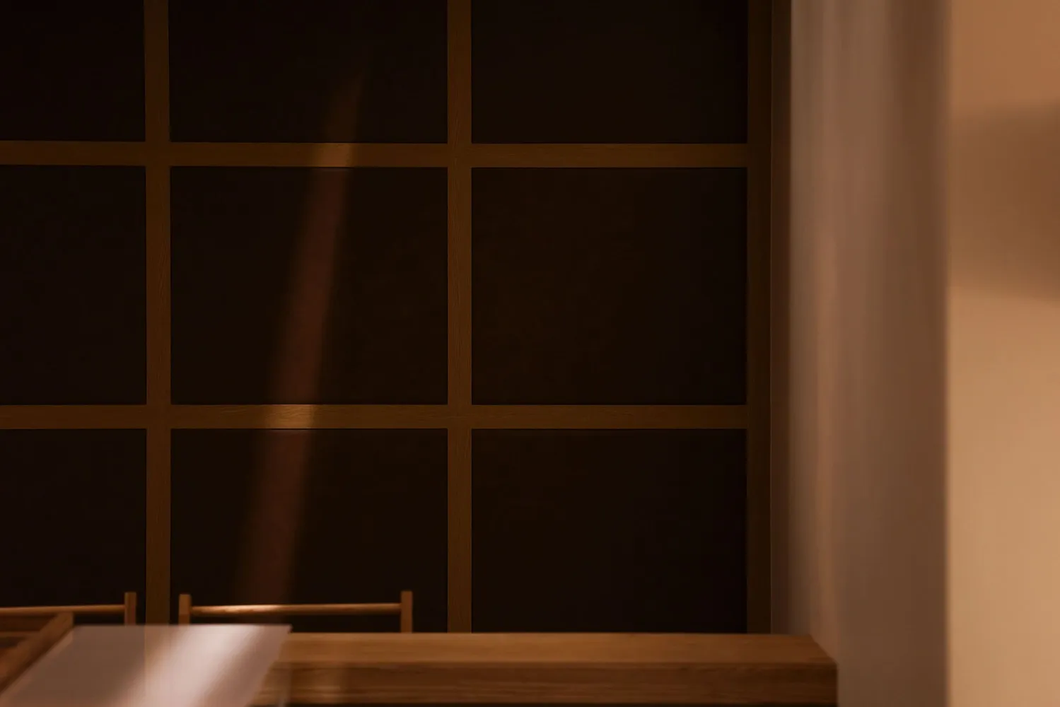 A minimalist interior design featuring a wooden cabinet with light shining through it, highlighting a modern and sleek aesthe
