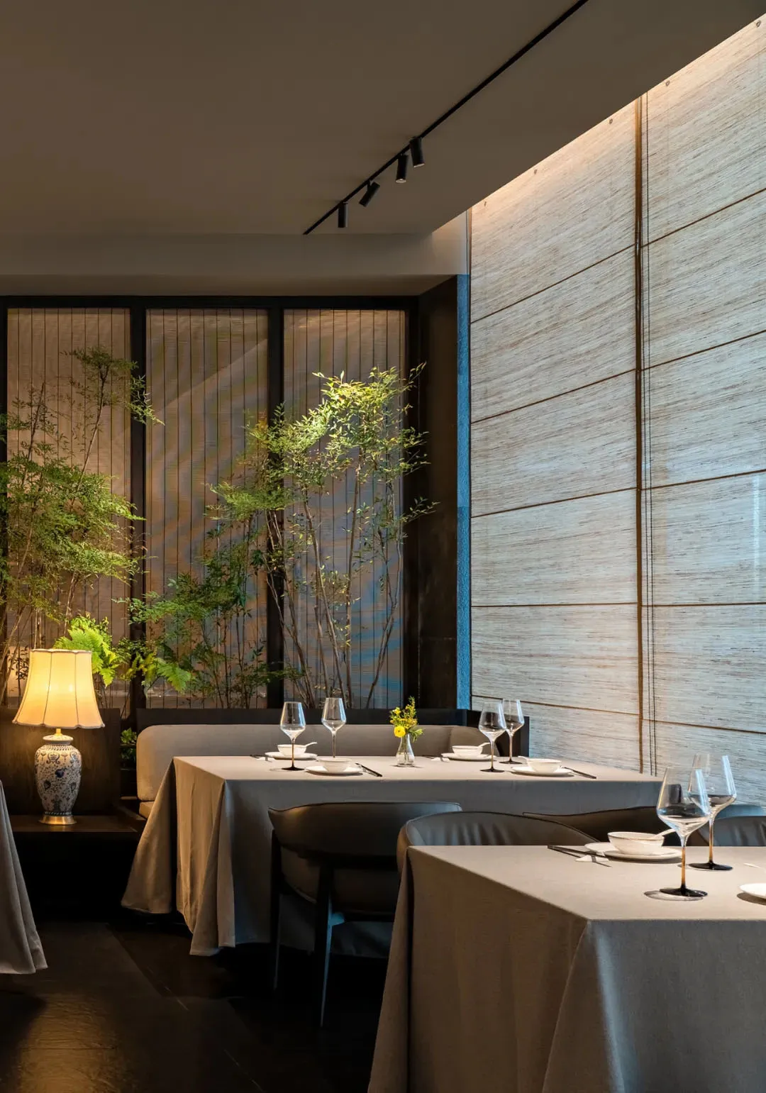 Modern dining room with textured wooden walls and plants.