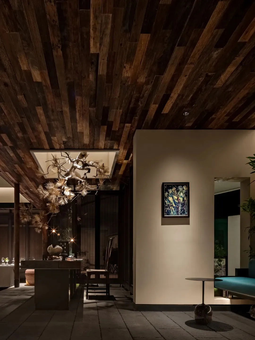 A cozy residential entrance featuring wooden walls and ceiling, with a hanging light fixture and a framed artwork on the wall