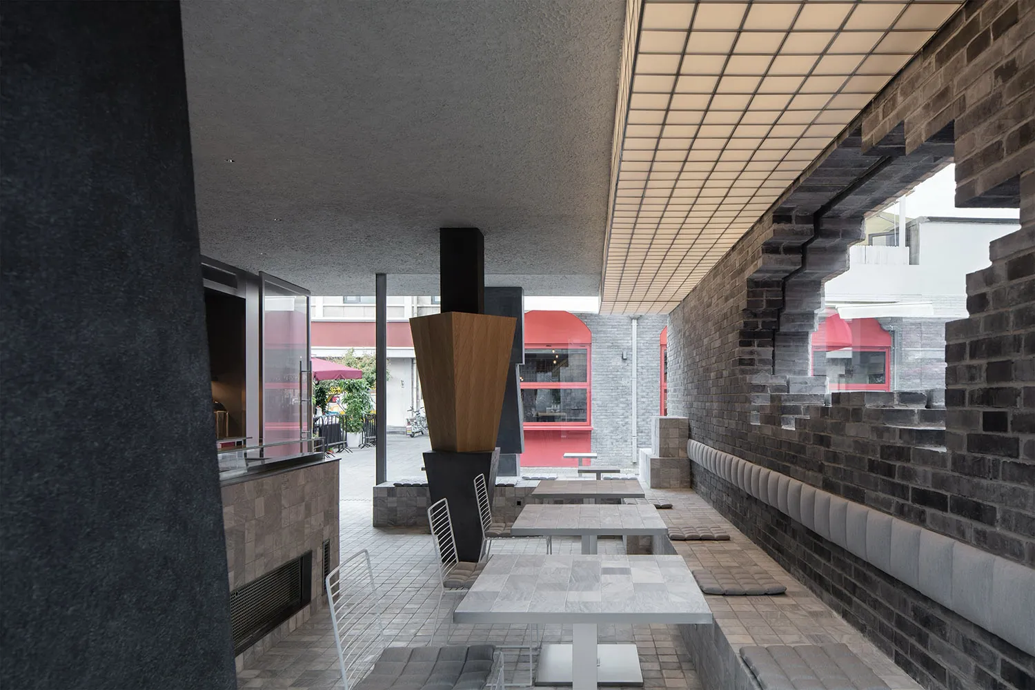 A modern, industrial-style cafe interior with concrete walls and a minimalist design.