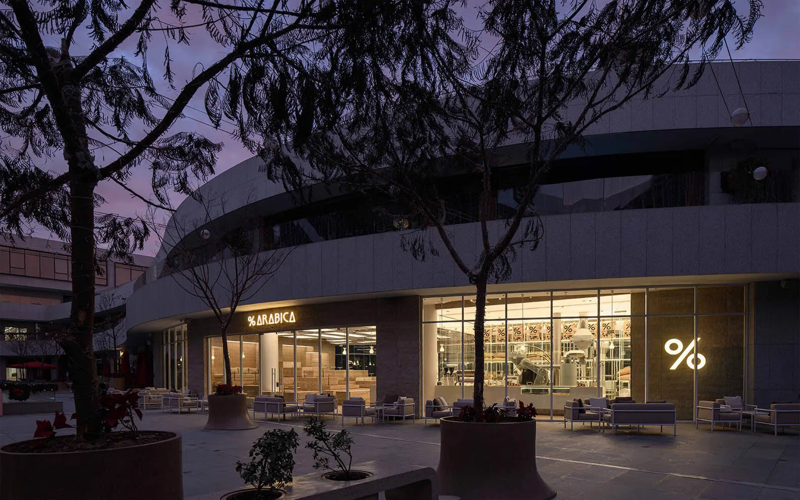 Modern, exterior view of a coffee shop with large glass windows.