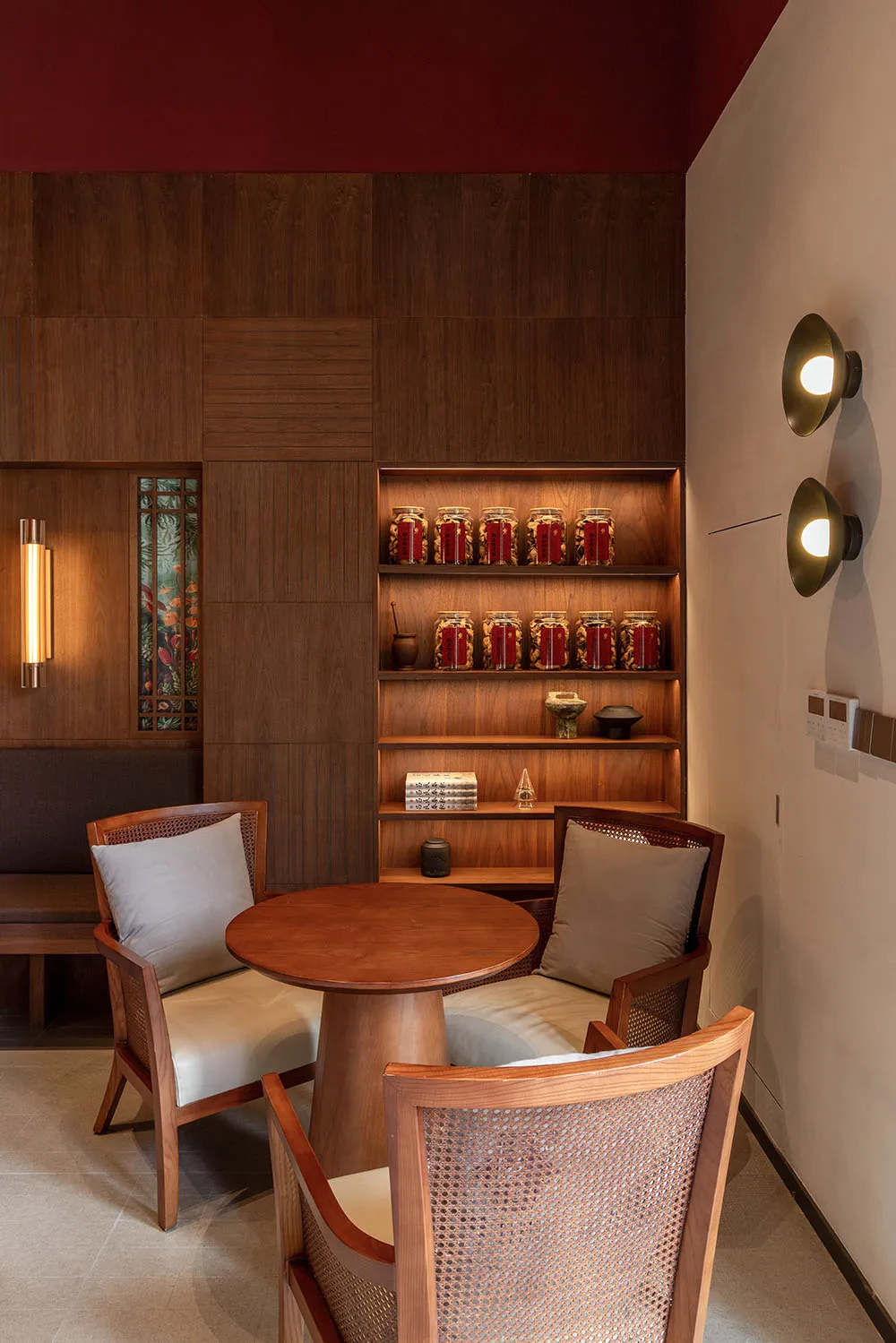 A modern restaurant interior with wooden furniture and shelves filled with jars.