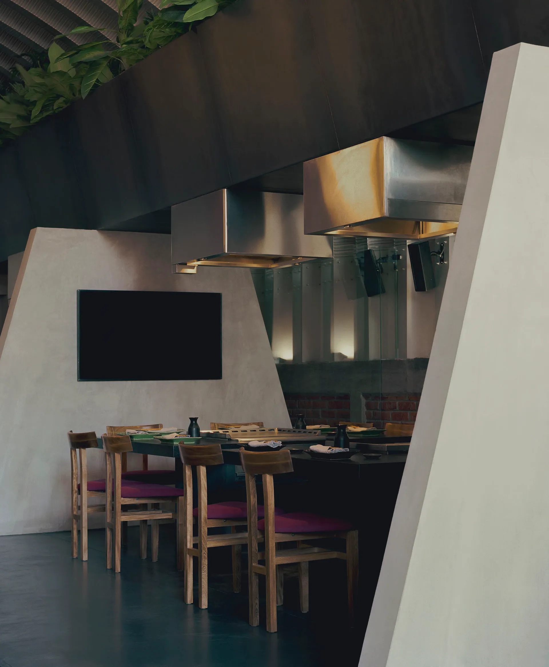 Modern kitchen with sleek metal countertop and stools.