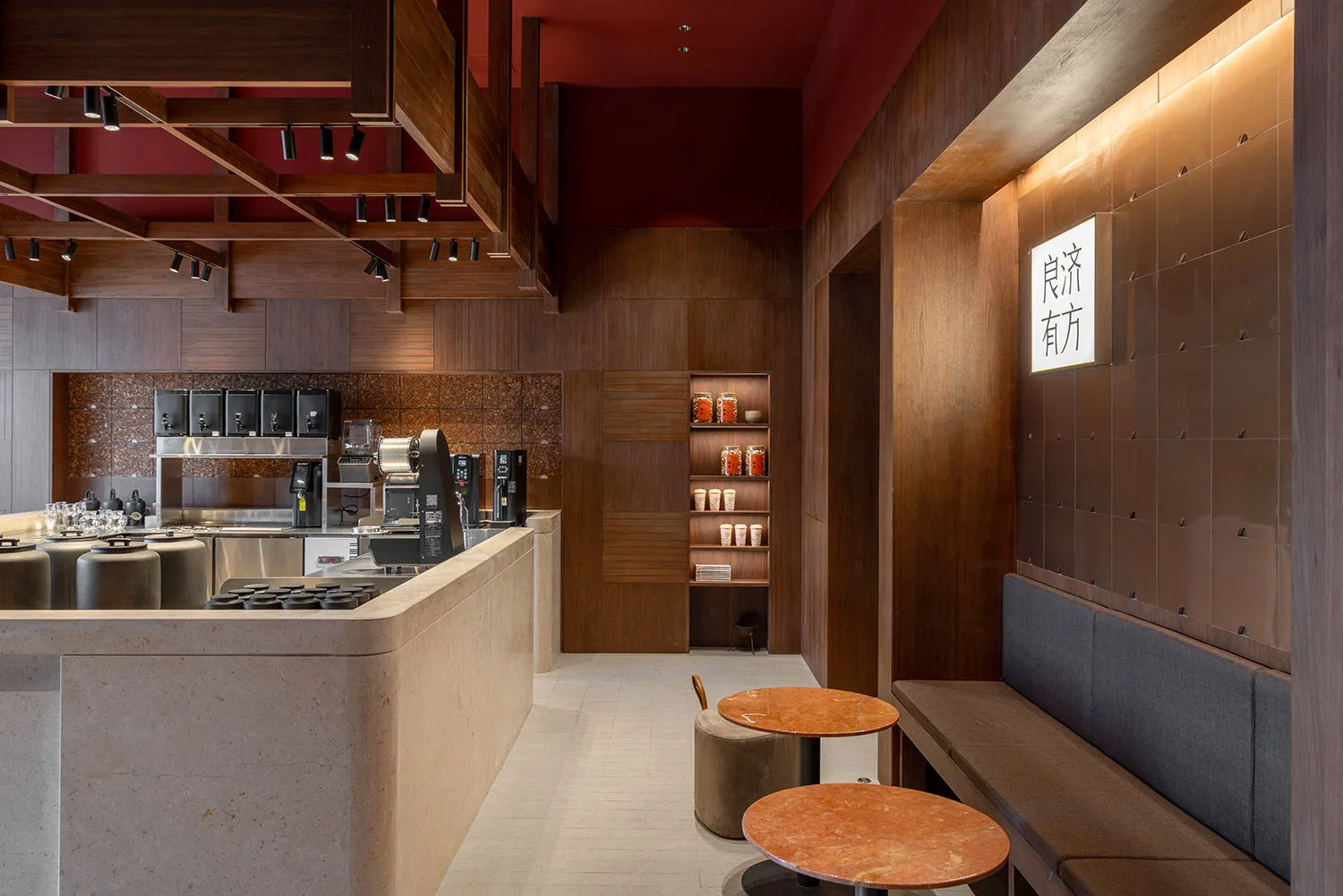 A modern restaurant bar with wooden and stone elements, illuminated by warm lights and featuring a sleek countertop with a se