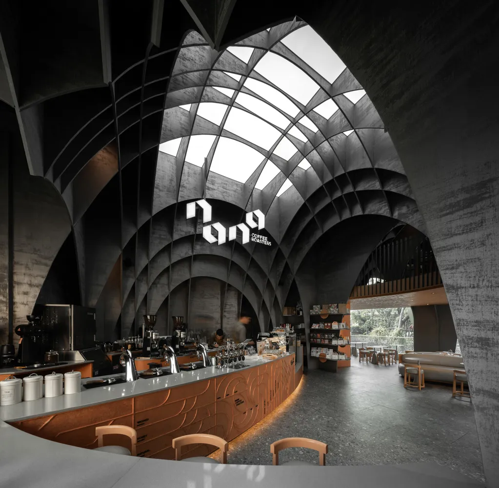 A modern, industrial-style coffee shop with concrete and metal finishes.