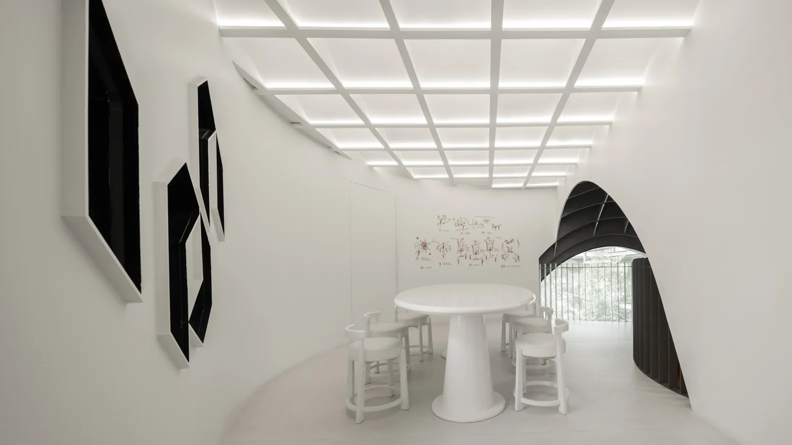 白色極簡風格的餐廳/咖啡廳室內設計,配有圓形白色餐桌、白色高腳椅,以及白色牆面上的黑色框畫