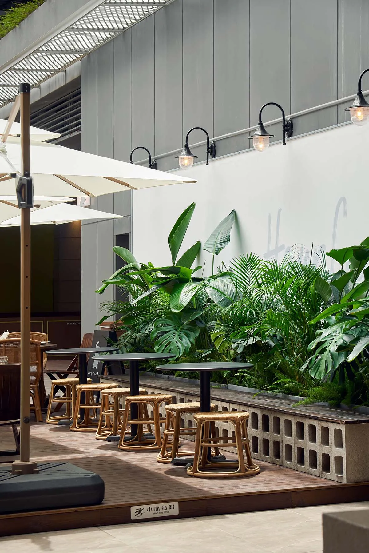 Modern minimalist cafe exterior with concrete, rattan, and glass materials.