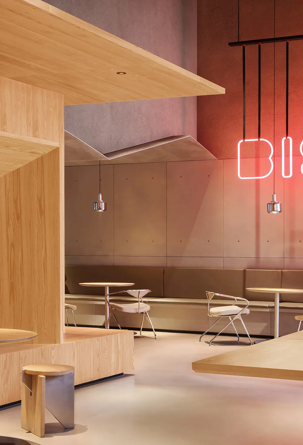 Modern restaurant interior with wooden tables, chairs, and benches.
