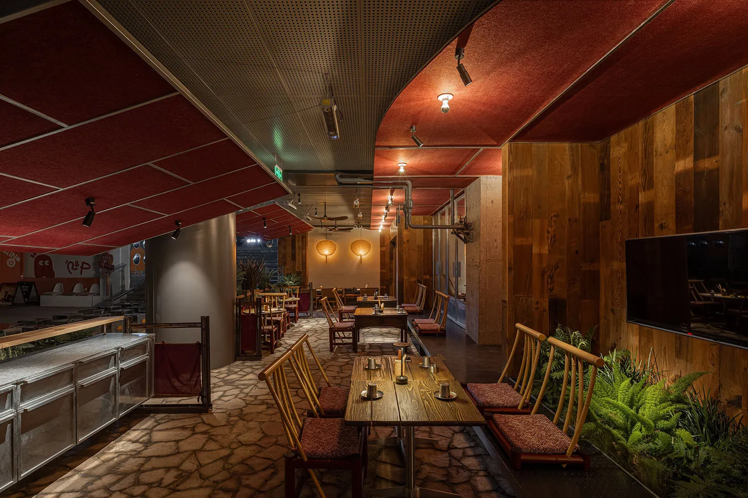 An industrial-style restaurant interior featuring wood, stone, and metal elements.