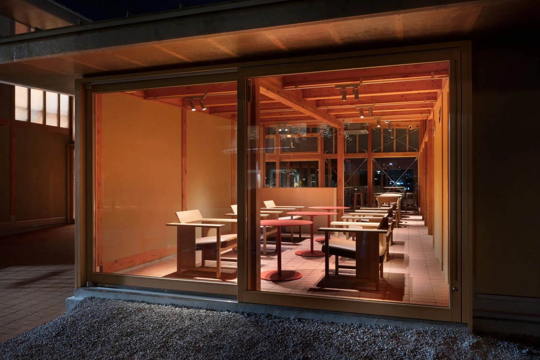 A modern restaurant interior featuring wooden tables and chairs, warm lighting, and a warm, inviting atmosphere.
